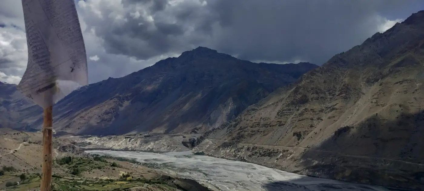 The wide Spiti river valley under dark clouds, seen from near Key